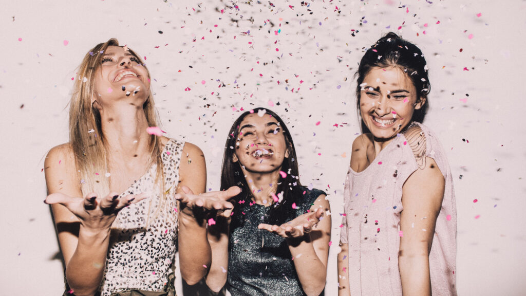 three women celebrating with confetti