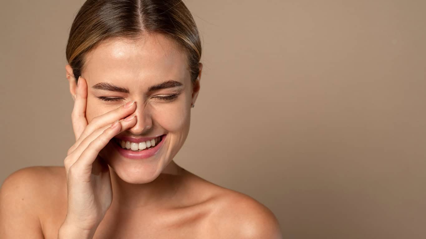 Smiling woman touching her face